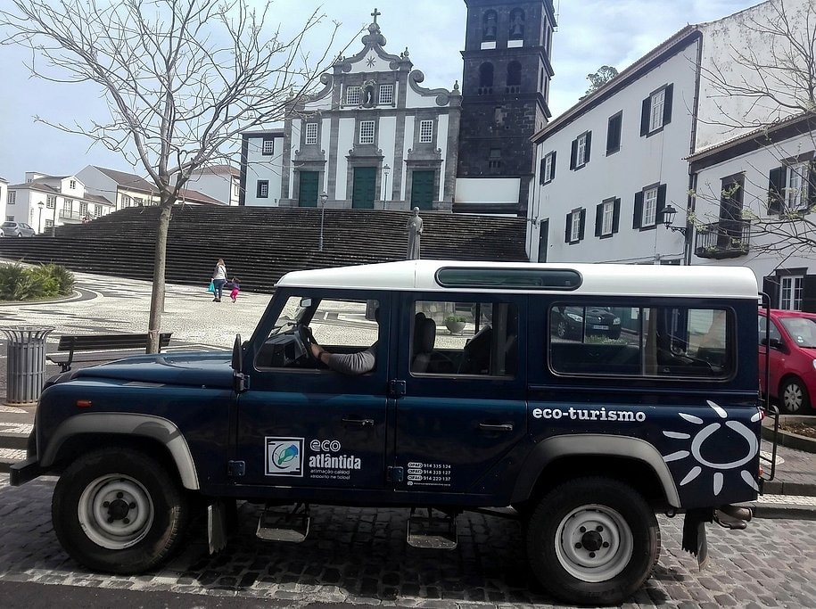 Jeep tour Land Rover parked by a white church in a São Miguel town square