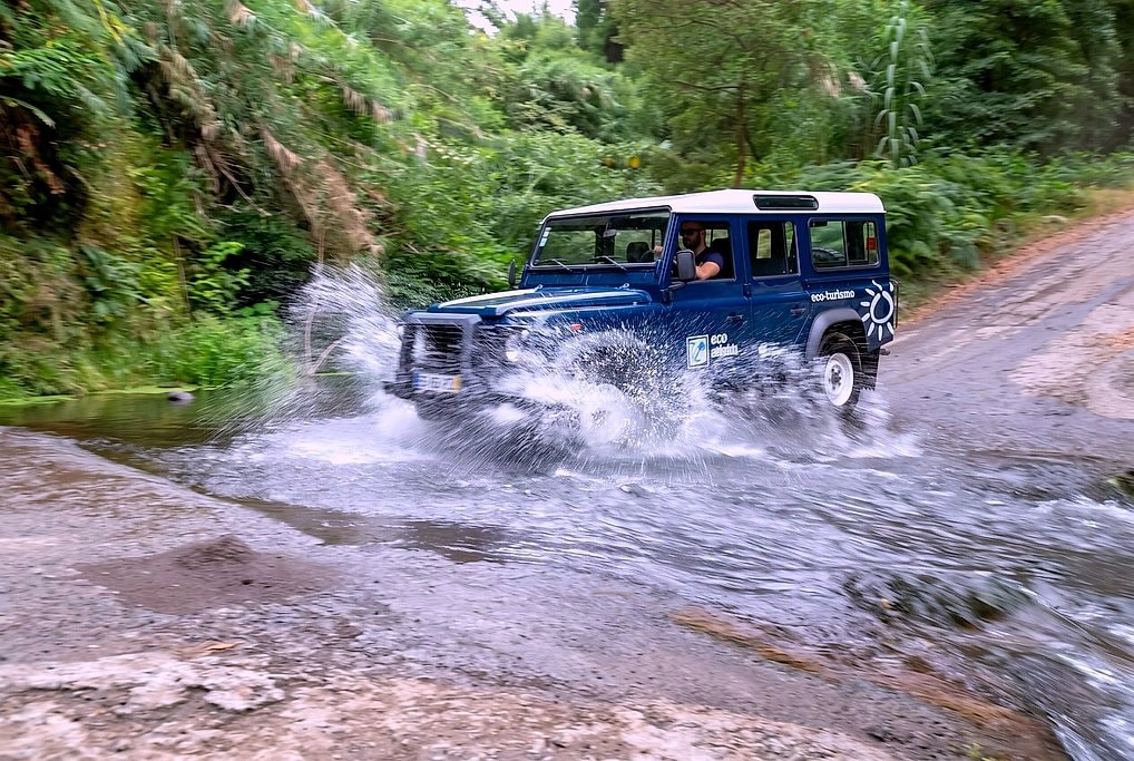 Jeep splashing through a forest stream on the off-road Serra da Tronqueira track