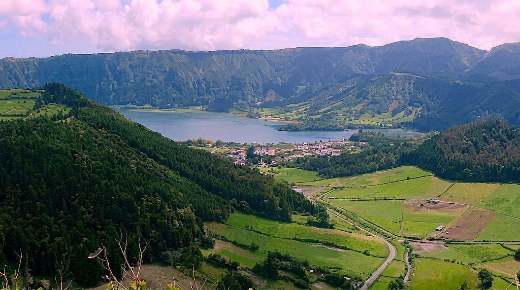 Sweeping view over Sete Cidades village and its lake, ringed by a patchwork of farmland and forested caldera walls
