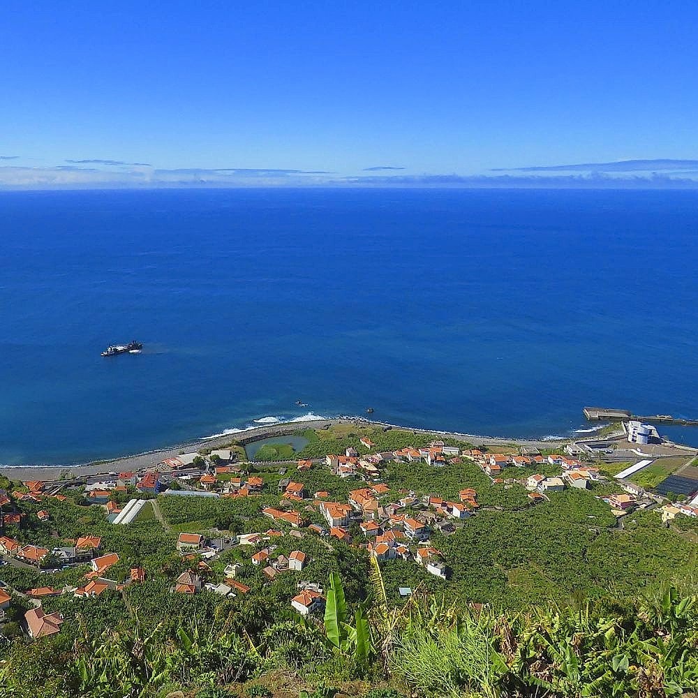 View from an open-top jeep over a Madeira coastal village and banana plantations.